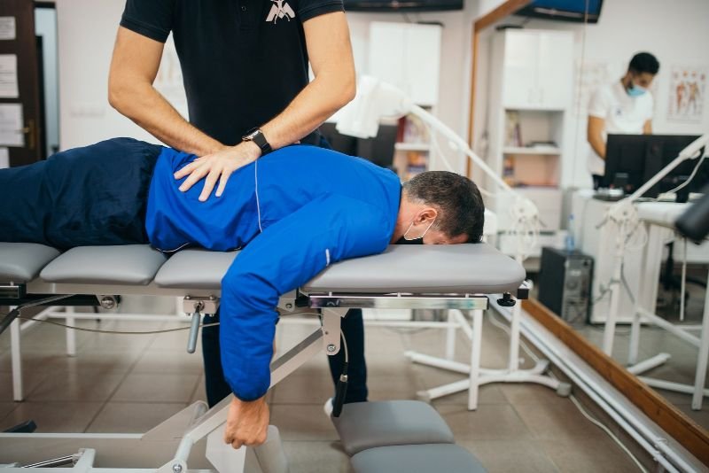 Practitioner adjusting the back of a patient lying on a treatment table