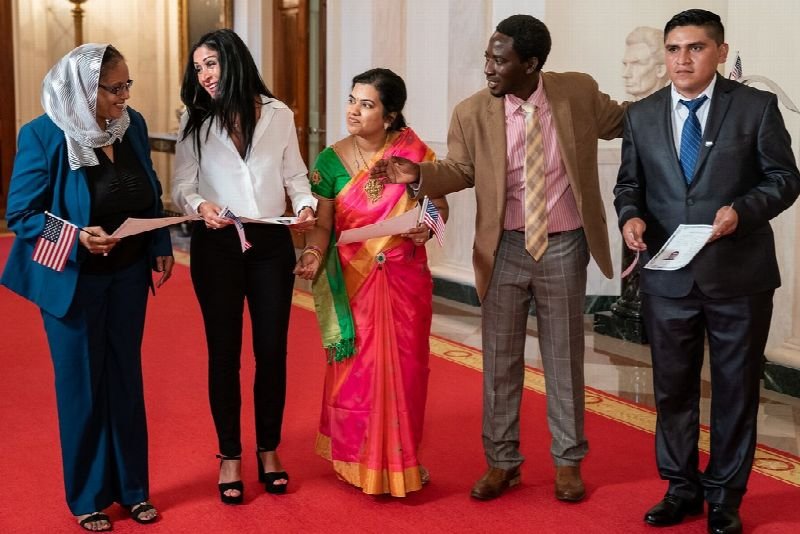 New citizens holding certificates at a ceremony