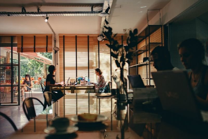 People working at desks in a sunlit open-plan office