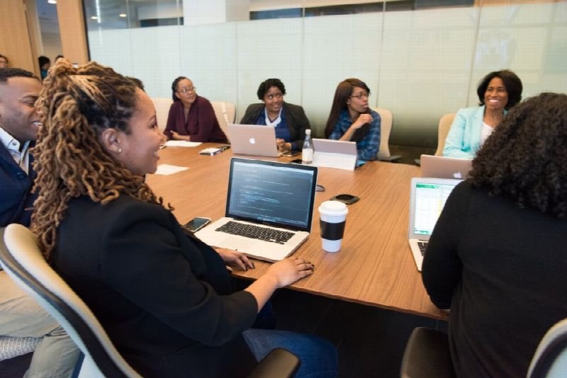 Team meeting around a boardroom table with laptops